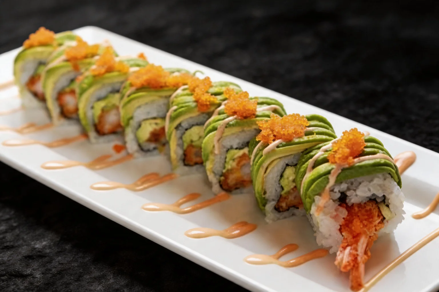 Maki Dragon sur une assiette blanche, fond sombre.