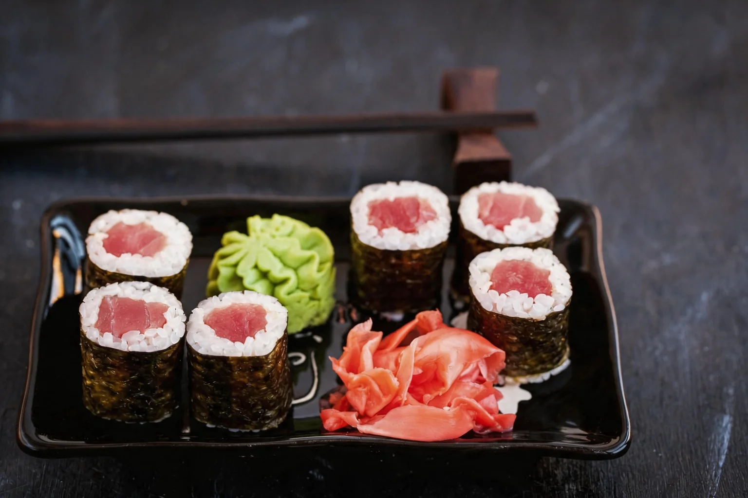 Makis sur un plateau noir, wasabi et gingembre.